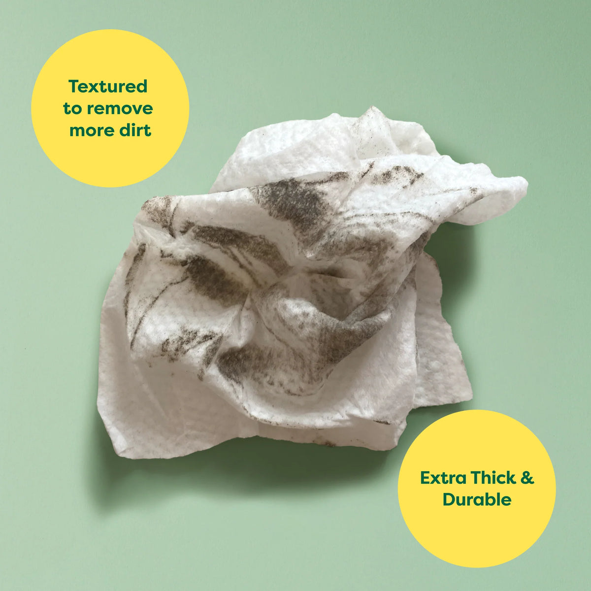 Textured cleaning cloth with dirt on a green background