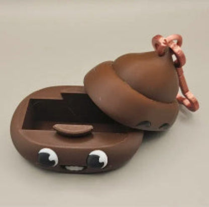 Cute brown ceramic poop-shaped container with a keychain on a light gray background