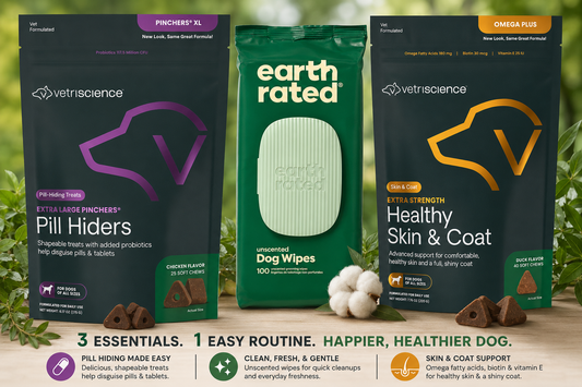 Three pet supplement packages arranged together on a wooden surface with green foliage in the background: a black Vetscience Pill Hiders bag on the left, a green Earth Rated dog wipes bag in the center, and a black Vetscience Healthy Skin & Coat Omega Plus bag on the right. Cotton balls and dog treats are placed in front, with promotional text along the bottom.